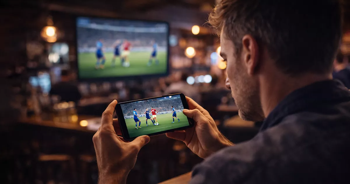 Supporter regardant un match de football en direct sur smartphone